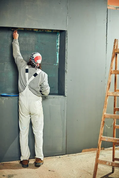 Pintor pintando paredes con un pincel en interiores . — Foto de Stock