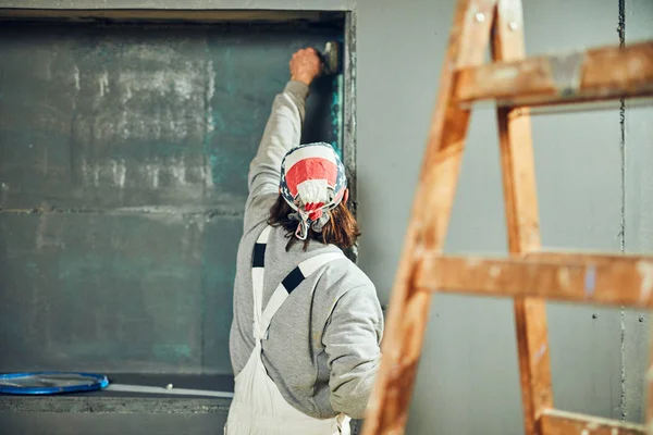 Schilder schilderen muren met een penseel binnenshuis. — Stockfoto