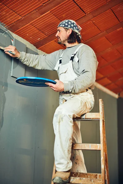 Pittore pittura pareti con un pennello all'interno . — Foto Stock