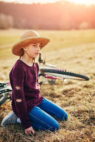 Bonito menina de dez anos com bicicleta no prado do campo — Fotografia de Stock