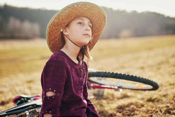 Nettes kleines zehnjähriges Mädchen mit Fahrrad auf der Wiese — Stockfoto