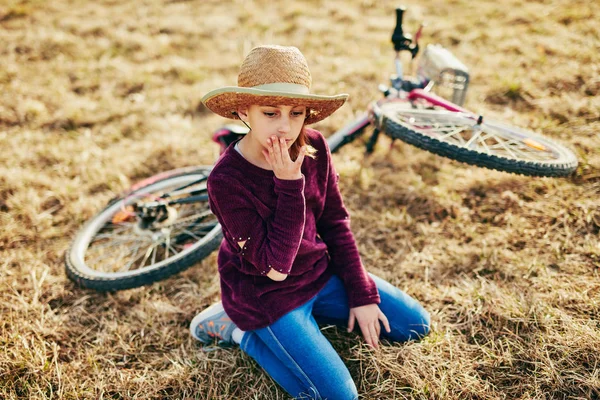 Schattige kleine tien jaar oud meisje met fiets op platteland weide — Stockfoto