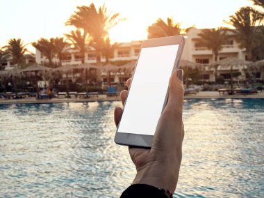 Yüzme havuzu yakınında cep telefonu kullanan genç kadın.