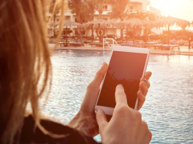 Yüzme havuzu yakınında cep telefonu kullanan genç kadın.