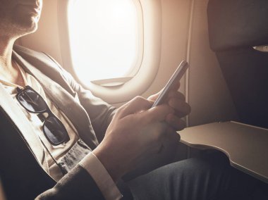 Uçağın içinde Smartphone kullanan adam.
