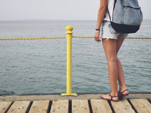 Single woman near the ocean / sea on a wooden pier.