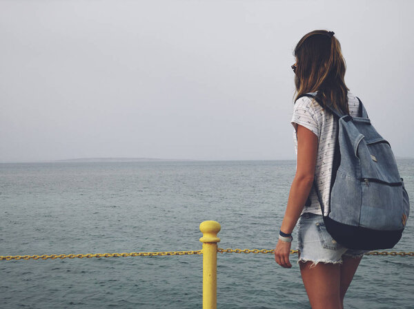 Single woman near the ocean / sea on a wooden pier.