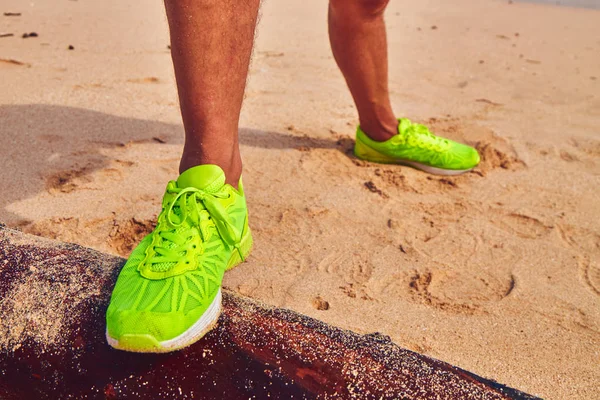 Sportler dehnt sich an einem tropischen Sandstrand. — Stockfoto