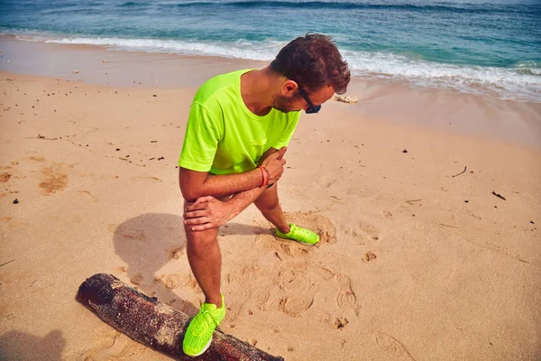 Deportista estirándose en una playa de arena tropical . —  Fotos de Stock