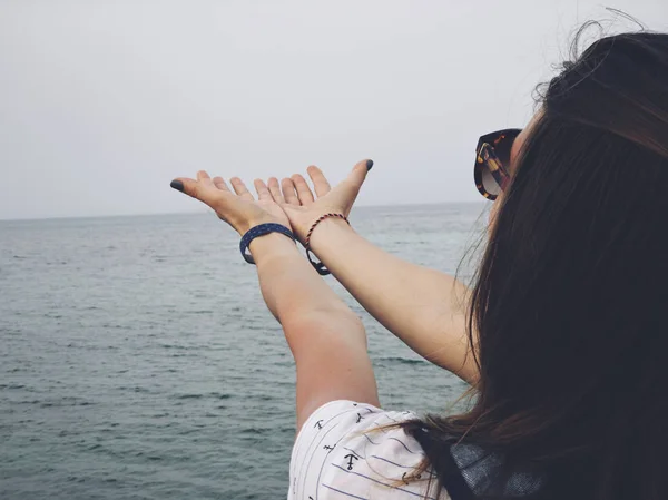 A tenger partján imádkozó karokkal rendelkező asszony. — Stock Fotó