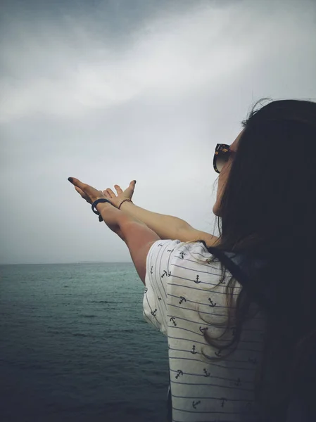 Kobieta z modlitwą broni na brzegu morza. — Zdjęcie stockowe