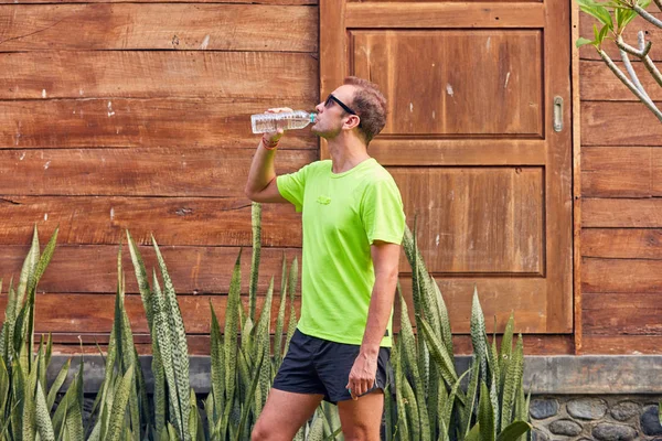 Desportista fazendo uma pausa com uma garrafa de água . — Fotografia de Stock