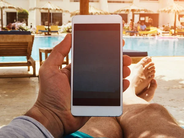Людина використовує мобільний телефон біля басейну . — стокове фото