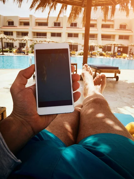 Man die mobiele telefoon in de buurt van het zwembad. — Stockfoto