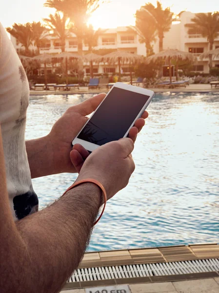 Hombre usando el teléfono celular cerca de la piscina . —  Fotos de Stock