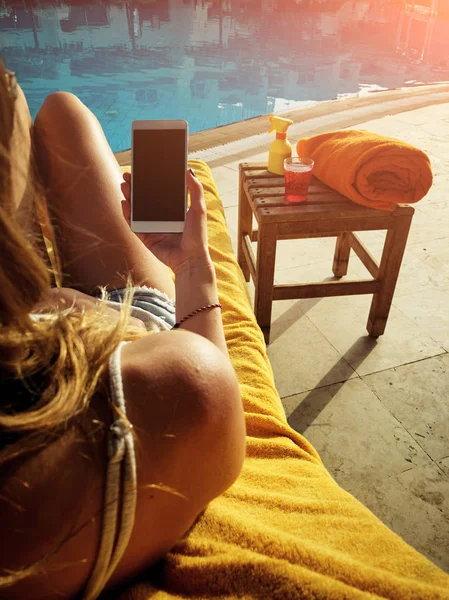 Молодая женщина с сотовым телефоном возле бассейна . — стоковое фото