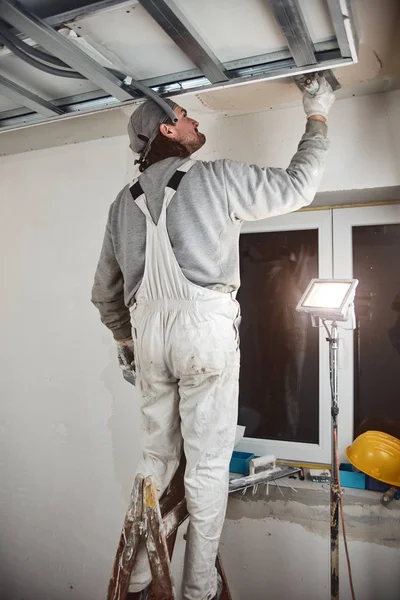 Workman plastering gypsum walls inside the house.