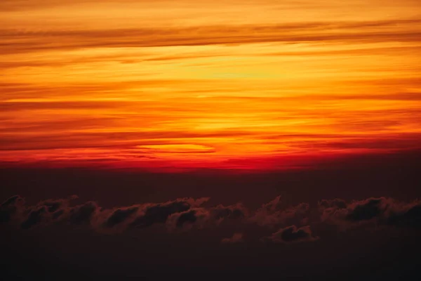 Salida / puesta del sol sobre las nubes y el horizonte en colores dorados . —  Fotos de Stock