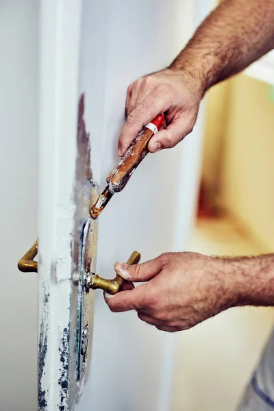 Разнорабочий с помощью зубила вокруг дверей, чтобы отмыть старую краску. . — стоковое фото