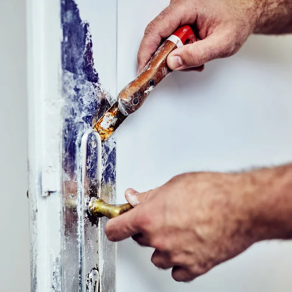 Handyman usando cinzel em torno de portas de bloqueio para esfregar a tinta velha . — Fotografia de Stock