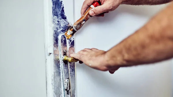 Handyman segítségével véső körüli ajtók zár tegy bozót a régi festék. — Stock Fotó