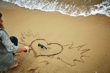 Bir kalp okyanus kuma çizim kız / deniz plaj.