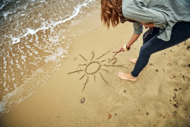 Bir kalp okyanus kuma çizim kız / deniz plaj.