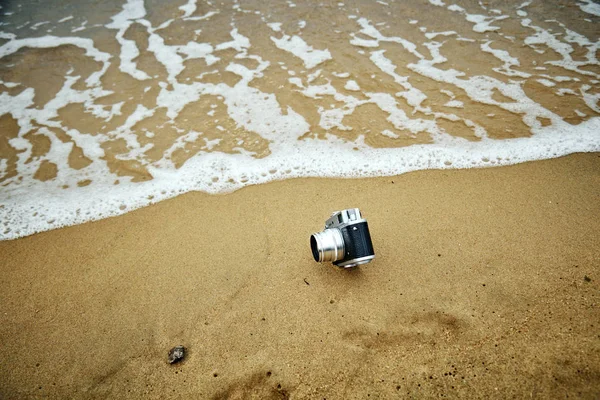 Retro kamera v písku na pláži. — Stock fotografie