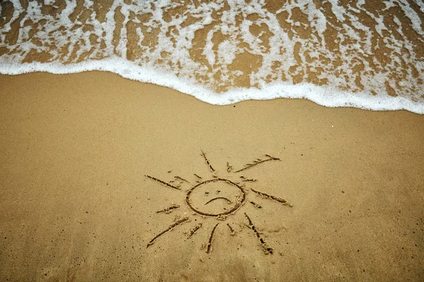 砂の中の太陽の悲しいシンボル - 夏は終わりました. — ストック写真