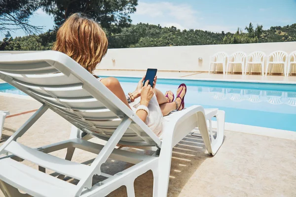 Fiatal nő használ cellphone közelében a medence. — Stock Fotó