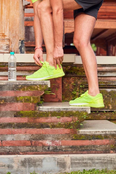 Deportista haciendo una pausa y atando zapatillas . — Foto de Stock