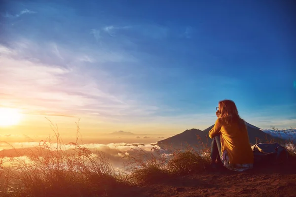 Mulher desfrutando de paisagem agradável e nascer do sol a partir de um topo da montanha — Fotografia de Stock