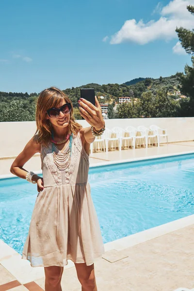 Carino giovane donna utilizzando il cellulare vicino alla piscina . — Foto Stock