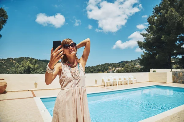 Carino giovane donna utilizzando il cellulare vicino alla piscina . — Foto Stock