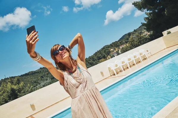 Linda mujer joven usando el teléfono celular cerca de la piscina . —  Fotos de Stock