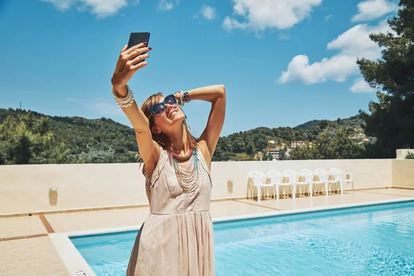 Linda mujer joven usando el teléfono celular cerca de la piscina . —  Fotos de Stock