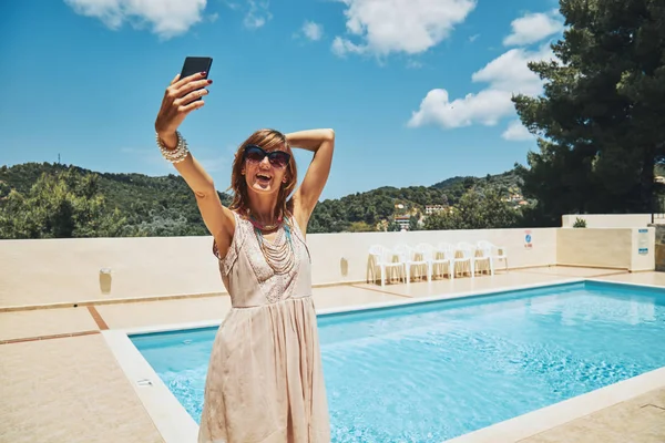 Мила молода жінка використовує мобільний телефон біля басейну . — стокове фото
