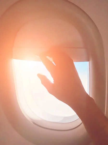 Рука пассажира закрывает окно в тени современного самолета . — стоковое фото