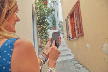 Sevimli genç kadın sokakta cep telefonu kullanarak.