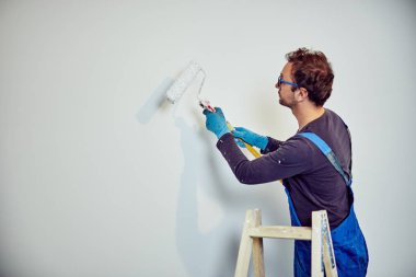 Ev içinde işçi boyama duvarları-yenileme düzeltmeleri.