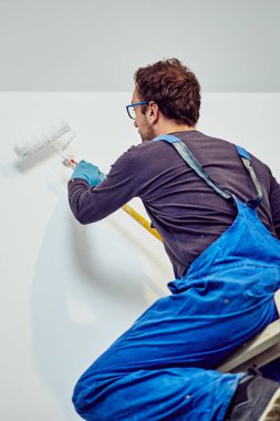 Ev içinde işçi boyama duvarları-yenileme düzeltmeleri.