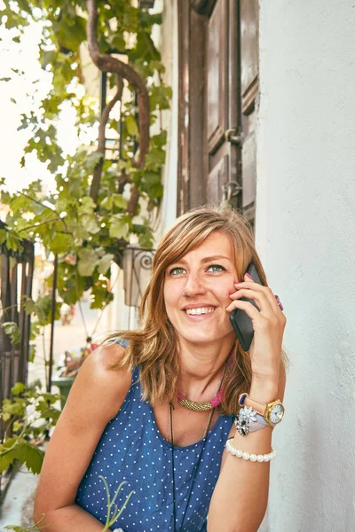Carino giovane donna utilizzando il cellulare sul portico / terrazzo di casa . — Foto Stock