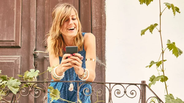 Χαριτωμένο νεαρή γυναίκα που χρησιμοποιεί το κινητό τηλέφωνο στο σπίτι βεράντα/βεράντα. — Φωτογραφία Αρχείου