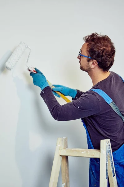 Paredes de pintura do trabalhador dentro da casa - consertos de renovação . — Fotografia de Stock