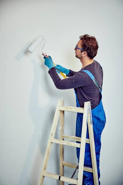 Worker painting walls inside the house - renovation fixes. — Stock Photo, Image