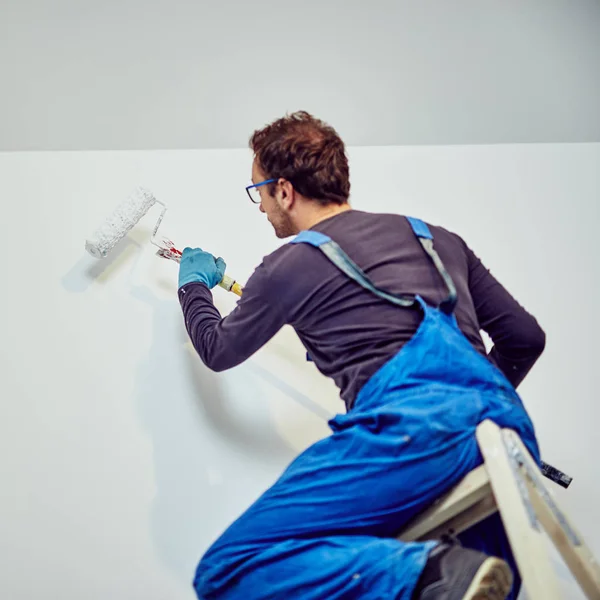 Paredes de pintura do trabalhador dentro da casa - consertos de renovação . — Fotografia de Stock