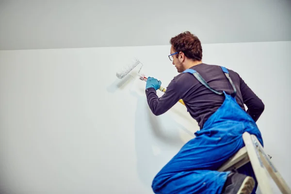 Worker painting walls inside the house - renovation fixes. — Stock Photo, Image