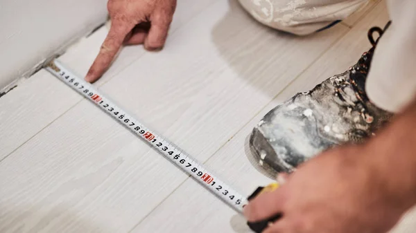 Trabajador usando cinta métrica para la renovación del hogar . — Foto de Stock