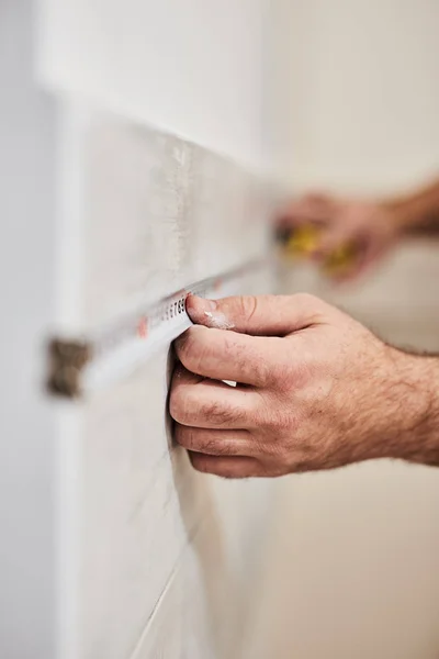 Trabajador usando cinta métrica para la renovación del hogar . — Foto de Stock