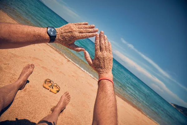 砂のトロピカに手でハート型のシンボルを作る男 — ストック写真